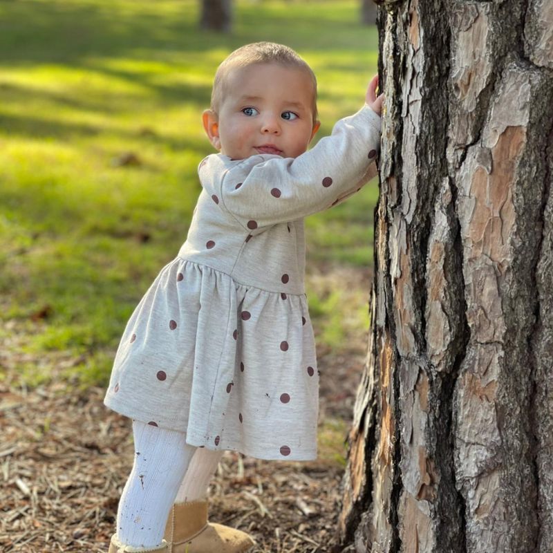 Junior FRACO Ellie Polka Dot Dress model standing against tree